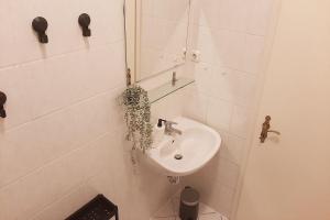 Baño blanco con lavabo y espejo en Gemütliches Apartment nahe der Elbe, en Magdeburgo