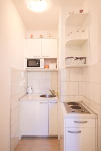 a white kitchen with a sink and a microwave at Sea Organ Apartment 2 (Oldtown Studio) in Zadar