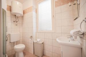 a bathroom with a toilet and a sink and a window at Sea Organ Apartment 2 (Oldtown Studio) in Zadar +21 photos