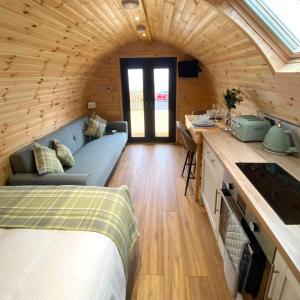 a room with a bed and a couch in a room at Meall Ard Self Catering Pod - Isle of South Uist in Pollachar