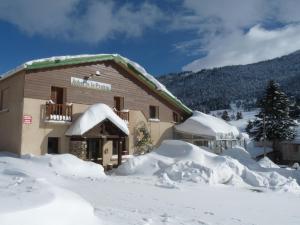 un edificio cubierto de nieve con nieve alrededor en Auberge La Prairie en Matemale