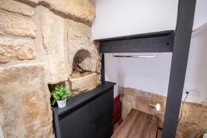 a bathroom with a stone wall and a black dresser at Planta baja en la muralla romana junto a la Catedral in Tarragona