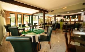 un ristorante con tavoli e sedie e un tavolo verde di HOTEL QUERINI Business Hotel Sandrigo a Sandrigo