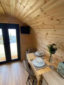 a wooden dining room with a table and chairs at Meall Ard Self Catering Pod - Isle of South Uist in Pollachar