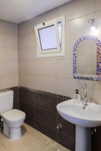 a bathroom with a toilet and a sink and a window at Al Deira Dahab Hotel in Dahab