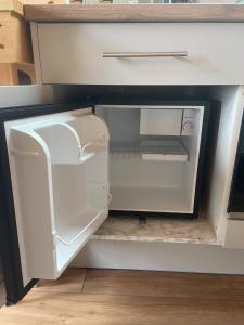 an empty refrigerator with its door open in a kitchen at Meall Ard Self Catering Pod - Isle of South Uist in Pollachar