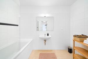 ein weißes Badezimmer mit einem Waschbecken und einem Spiegel in der Unterkunft Arbio I Design Apartments in Favoriten Vienna in Wien