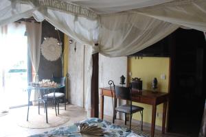 1 dormitorio con mesa y sillas y comedor en LA LIANE DE JADE 974-Lodge Le Palissandre - jacuzzi privatif - piscine, en Le Bois de Nèfles