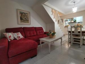 een woonkamer met een rode bank en een tafel bij Casa Alfonso Toledo Más que una casa un hogar in Toledo