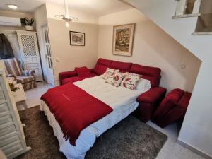 um quarto com uma cama vermelha e um sofá vermelho em Casa Alfonso Toledo Más que una casa un hogar em Toledo