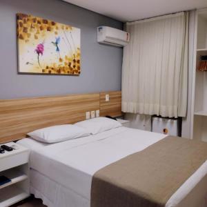 a bedroom with a bed and a painting on the wall at Hotel Três Caravelas in Fortaleza