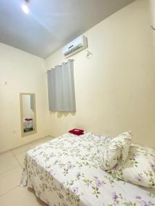 a bedroom with a bed and a air conditioner at Pousada Mineira in Barreirinhas