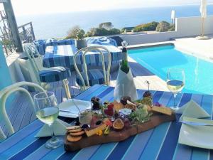 a table with a plate of food and wine glasses at 65onCliff in Gansbaai