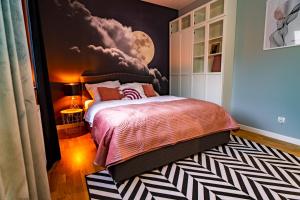 a bedroom with a bed with a painting on the wall at ApartamentySnu, Słoneczny Komfort, Centrum in Radom