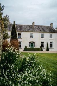 duży biały dom z zielonym dziedzińcem w obiekcie Ballymote Country House w mieście Downpatrick