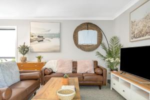 a living room with a couch and a tv at Stylish 4BR Villa with Office l Modern and Comfy in Marsden Park