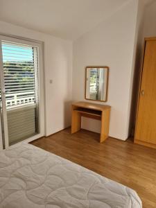 une chambre avec un lit, un miroir et une fenêtre dans l'établissement Apartment Ante, à Račišće