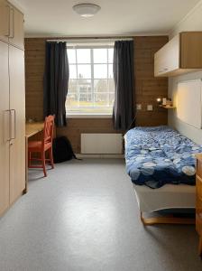 um quarto com uma cama, uma secretária e uma mesa em Sund sommerhotell, Inderøy em Straumen