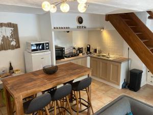 a kitchen with a wooden table and some chairs at Petite Maison en Provence in Plaisians