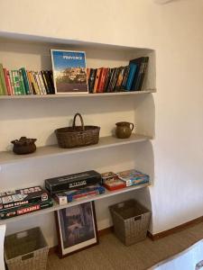półka z książkami i kosz na niej w obiekcie Petite Maison en Provence w mieście Plaisians