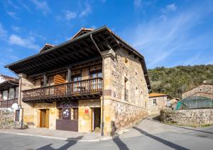 un edificio antiguo con balcón en la parte superior en Apartamentos Los Edules en Treceño