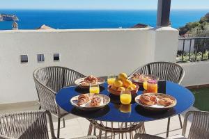 a blue table with plates of food on a balcony at Stylish 4 Bedroom Casa with Sea Views, Air Con & Communal Swimming Pool in La Herradura