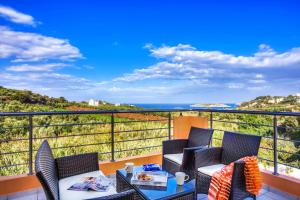 balcón con mesa, sillas y vistas al océano en Cyan Icons Villas Kalyves Chania, en Kalyves