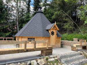 a small wooden dog house with a black roof at penzion Stará Škola in Nižná Boca