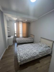 a bedroom with two beds and a window at 3-room elite apartment Alexandria in Bishkek