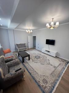 a living room with a couch and a flat screen tv at 3-room elite apartment Alexandria in Bishkek