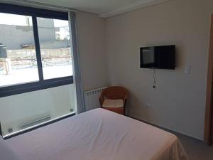 1 dormitorio con 1 cama y TV de pantalla plana en Depto Nuevo Belgrano en Villa Mercedes