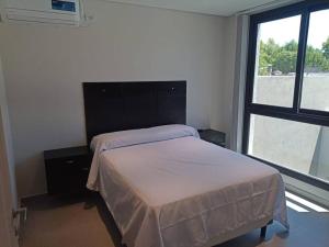 1 dormitorio con cama y ventana grande en Depto Nuevo Belgrano en Villa Mercedes