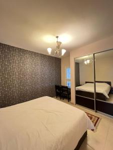 - une chambre avec un lit blanc et un miroir dans l'établissement Thara Real Estate, à Sowayma