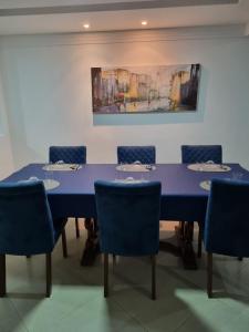 uma sala de conferências com uma mesa azul e cadeiras em Zênit Hostel da Cris em Cabo Frio