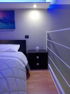 a bedroom with a white bed and a night stand at Maison Damas in Barletta