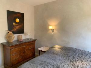 サリアンにあるLa Villa d'Arthureのベッドルーム1室(ベッド1台付)が備わります。壁には絵画が飾られています。