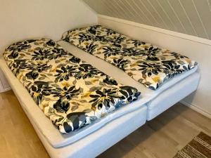 two beds in a room with flowers on them at Holiday home Sæbøvik in Sæbøvik