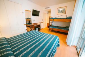 een slaapkamer met een bed, een stapelbed en een bureau bij Hotel Continental in San Benedetto del Tronto