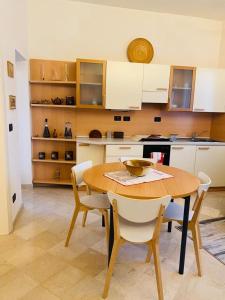 a kitchen with a wooden table and white cabinets at Veba Ferrara Centro in Ferrara