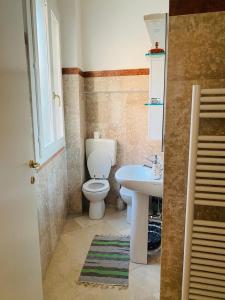 La salle de bains est pourvue de toilettes blanches et d'un lavabo. dans l'établissement Veba Ferrara Centro, à Ferrare