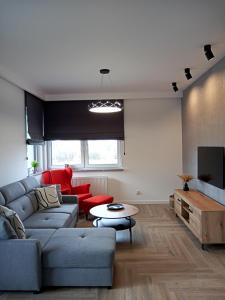 a living room with a couch and a table at Apartament SEVENTH HEAVEN in Uniejow