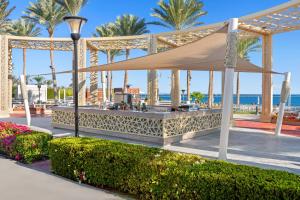 a gazebo at the beach with palm trees and the ocean at Rixos Premium Seagate in Sharm El Sheikh