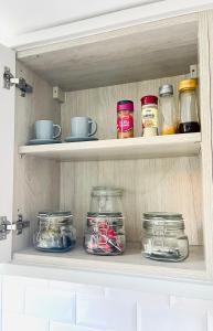 a shelf with jars of food in a kitchen at Beautiful, 1 Bedroom Renovated Cottage in Leicester