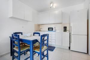 a kitchen with a blue table and chairs and a refrigerator at Casa Isa in Cotillo +15 photos