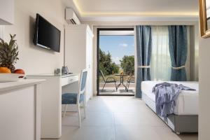 1 Schlafzimmer mit einem Bett und einem Balkon mit einem Tisch in der Unterkunft Light Blue Hotel in Nea Kallikratia