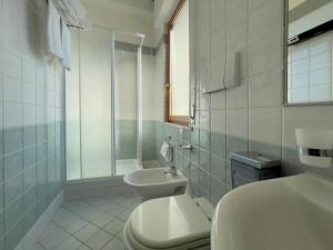 a white bathroom with a sink and a toilet at La Lanterna in Silvi Marina