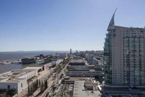 une vue aérienne sur une ville avec un grand bâtiment dans l'établissement RENT4REST LISBON PARQUE DAS NAÇÕES 17Th FLOOR RIVER VIEW, à Lisbonne