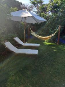 a hammock with an umbrella and chairs in a yard at Osborne Lodge in Ryde