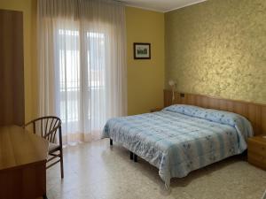 een slaapkamer met een bed, een stoel en een raam bij La Lanterna in Silvi Marina
