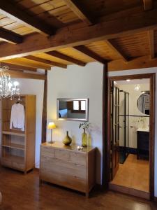 a living room with a dresser and a mirror at Alojamientos La Herrera in San Esteban de la Sierra